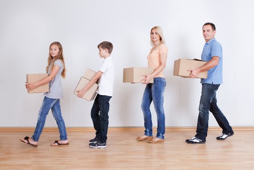 Movers handling packed boxes in a central London apartment